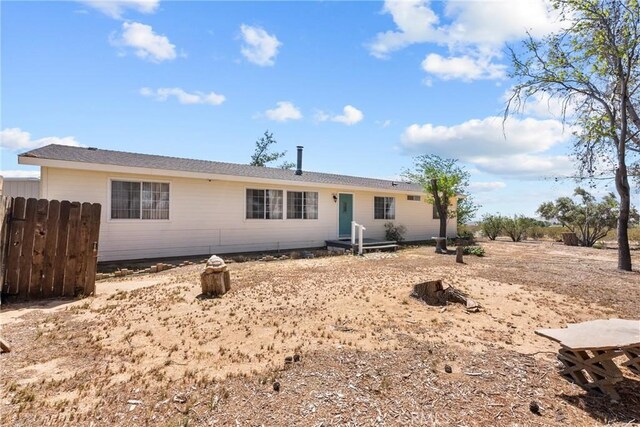 rear view of property featuring fence