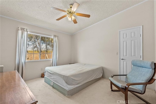 bedroom featuring crown molding, carpet floors, a ceiling fan, and a textured ceiling