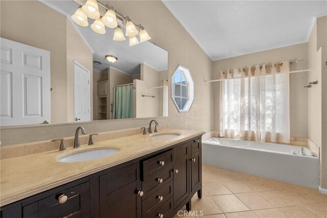 full bath featuring double vanity, tile patterned flooring, a sink, and a bath