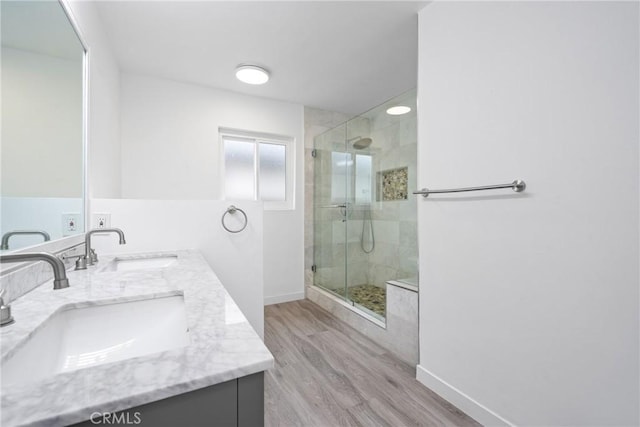 full bath with wood finished floors, a shower stall, and a sink
