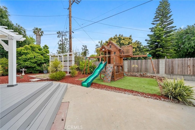 view of playground with a yard, a patio, and fence
