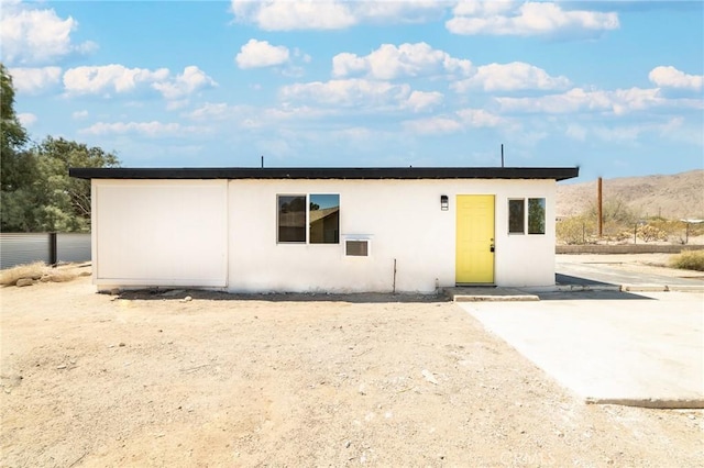 back of house featuring fence and stucco siding