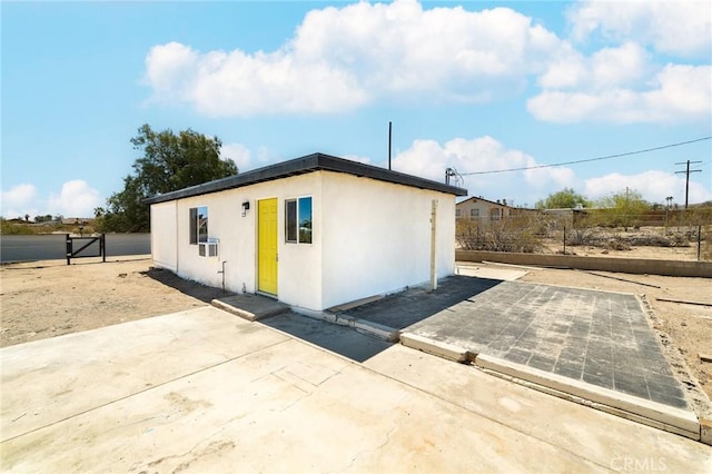 view of side of home featuring fence, a patio, and stucco siding