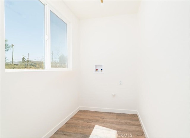 laundry area featuring washer hookup, baseboards, laundry area, and wood finished floors