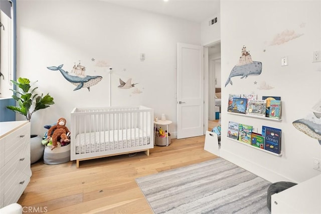 4322 Gentry Ave Unit 104, Studio City, CA 91604 - bedroom with visible vents, a crib, and wood finished floors