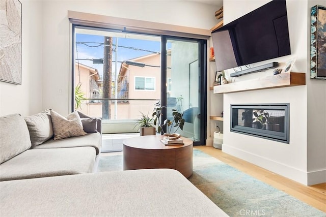 4322 Gentry Ave Unit 104, Studio City, CA 91604 - living room featuring baseboards, a glass covered fireplace, and wood finished floors