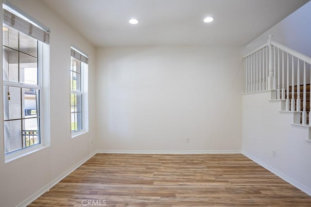 spare room featuring baseboards, recessed lighting, and wood finished floors