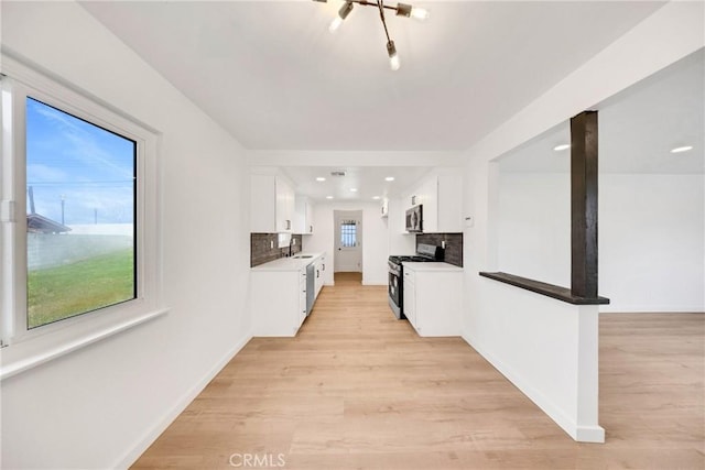 4832 Olive St, Montclair, CA 91763 - kitchen with appliances with stainless steel finishes, white cabinets, backsplash, and light wood finished floors