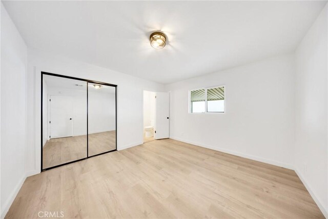 4832 Olive St, Montclair, CA 91763 - unfurnished bedroom featuring light wood-style floors, baseboards, and a closet