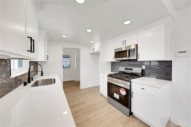 4832 Olive St, Montclair, CA 91763 - kitchen featuring a sink, light wood finished floors, light countertops, stainless steel appliances, and backsplash