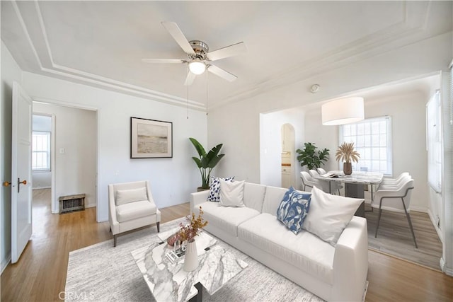 3712 Virginia Rd, Los Angeles, CA 90016 - living room with baseboards, light wood-type flooring, arched walkways, a tray ceiling, and a ceiling fan