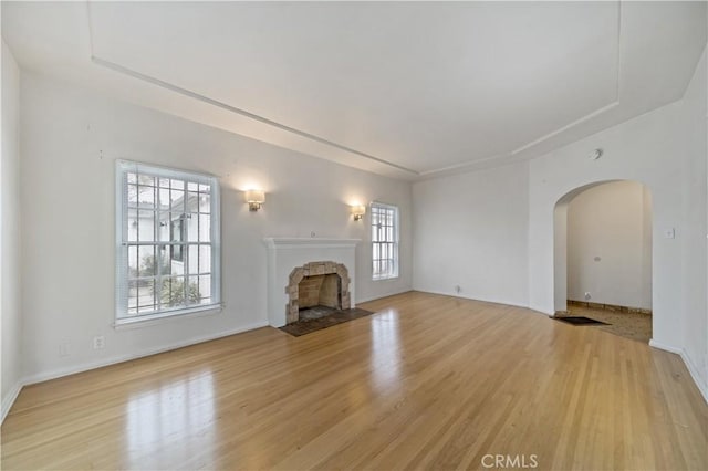 3712 Virginia Rd, Los Angeles, CA 90016 - unfurnished living room featuring plenty of natural light, a stone fireplace, and light wood-type flooring