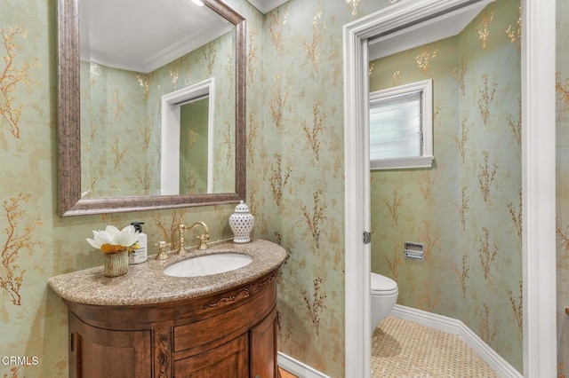 bathroom with vanity, baseboards, ornamental molding, and toilet
