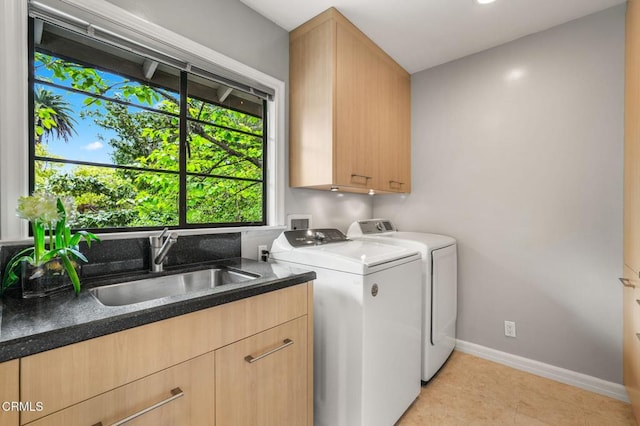 laundry area with light tile patterned flooring, washer and dryer, baseboards, a sink, and cabinet space
