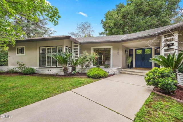 view of front of property featuring stucco siding and a front yard