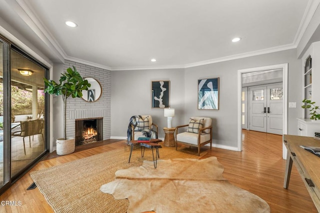sitting room featuring recessed lighting, ornamental molding, and a brick fireplace