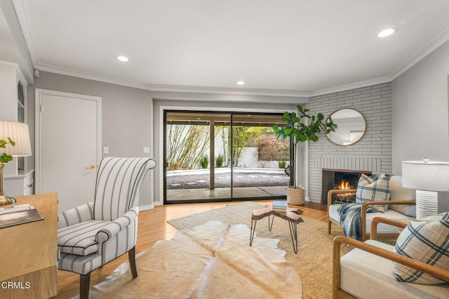 living area featuring crown molding, a fireplace, wood finished floors, baseboards, and recessed lighting