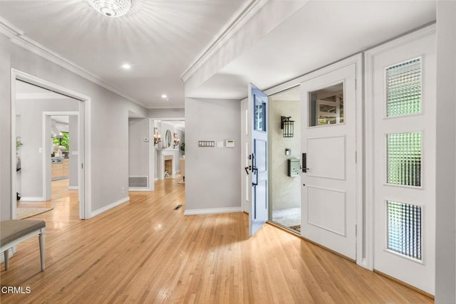 foyer featuring crown molding, light wood finished floors, recessed lighting, baseboards, and visible vents