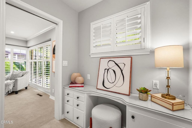 office space featuring baseboards, visible vents, and light carpet