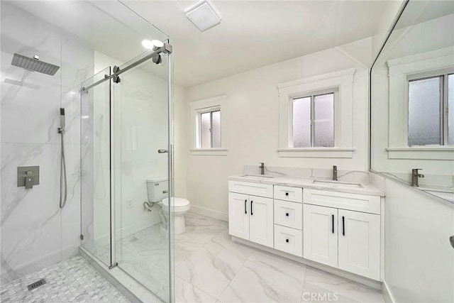 bathroom with double vanity, toilet, a marble finish shower, and a sink