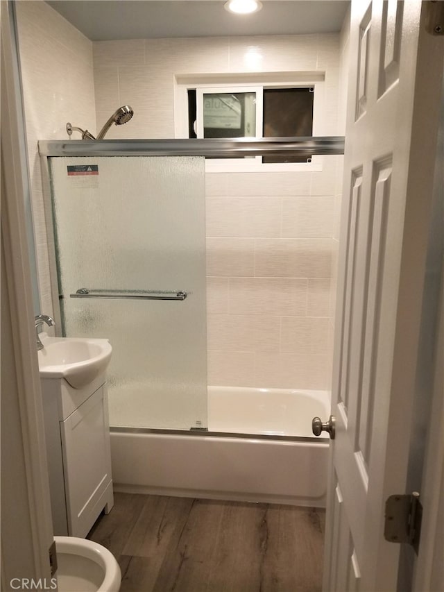 bathroom with shower / bath combination, wood finished floors, and vanity