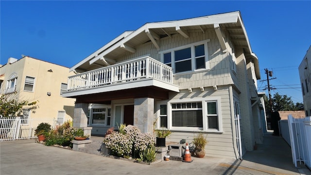 view of front of home featuring fence and a balcony