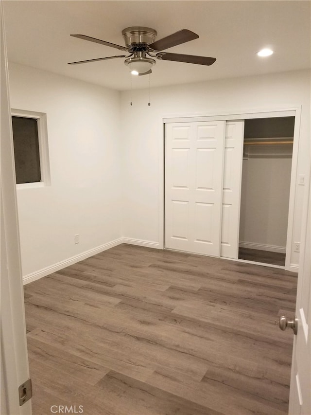 unfurnished bedroom with a ceiling fan, wood finished floors, baseboards, a closet, and recessed lighting