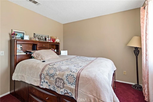 carpeted bedroom with a textured ceiling, baseboards, and visible vents