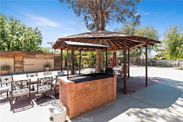 view of patio with fence, outdoor dining area, and a gazebo