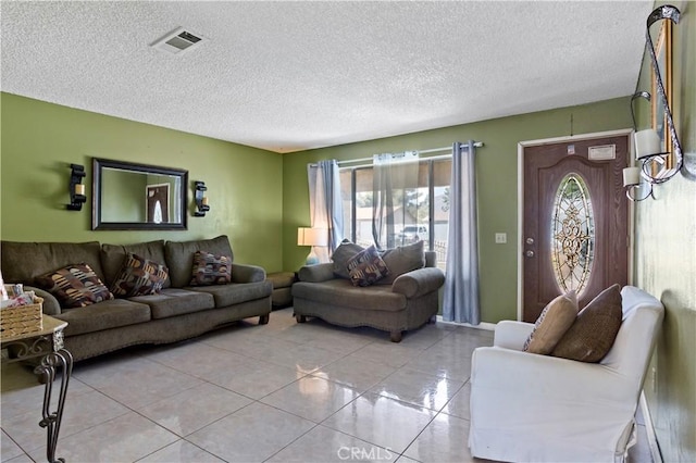 living area with light tile patterned floors, a textured ceiling, visible vents, and a wealth of natural light