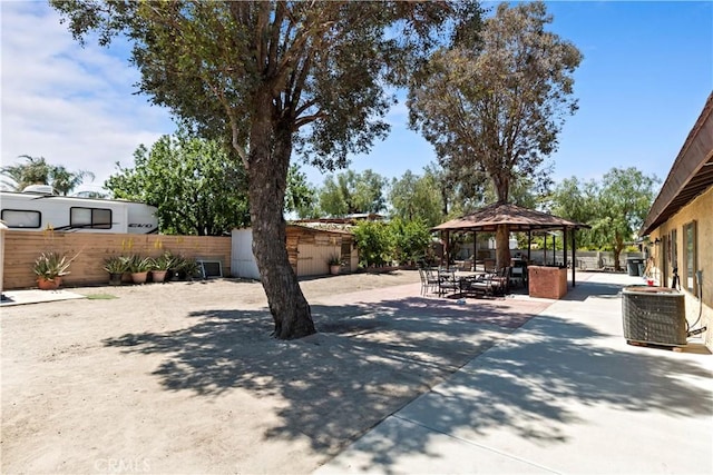view of yard featuring central air condition unit, a patio, a gazebo, and fence