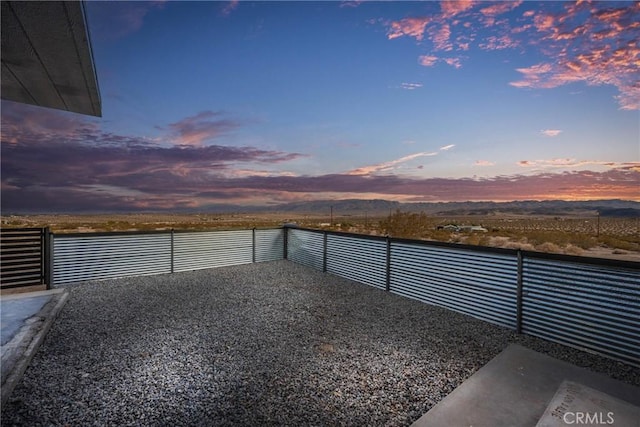 view of patio featuring fence and a water view
