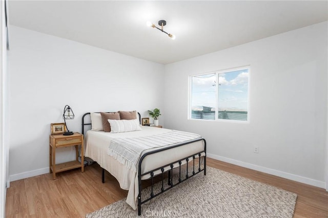 bedroom with baseboards and light wood-style flooring