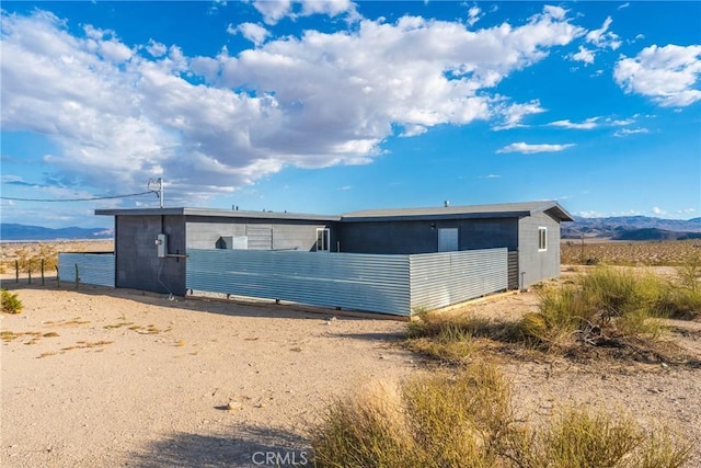 view of side of home with a mountain view and concrete block siding