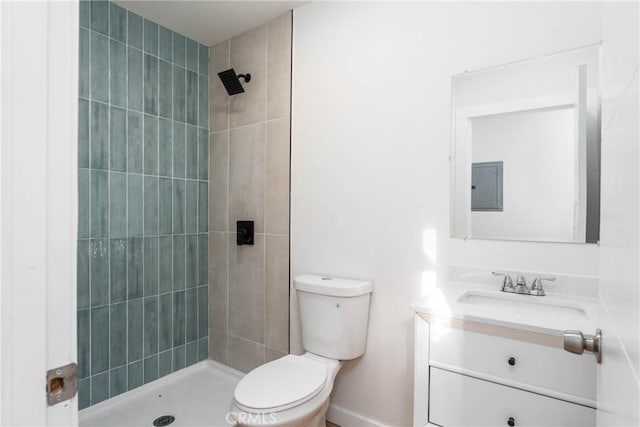 full bathroom with electric panel, a tile shower, vanity, baseboards, and toilet