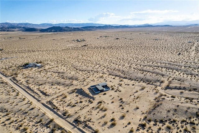 drone / aerial view featuring a mountain view, view of desert, and a rural view