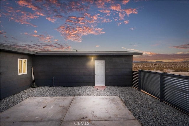 garage at dusk featuring fence