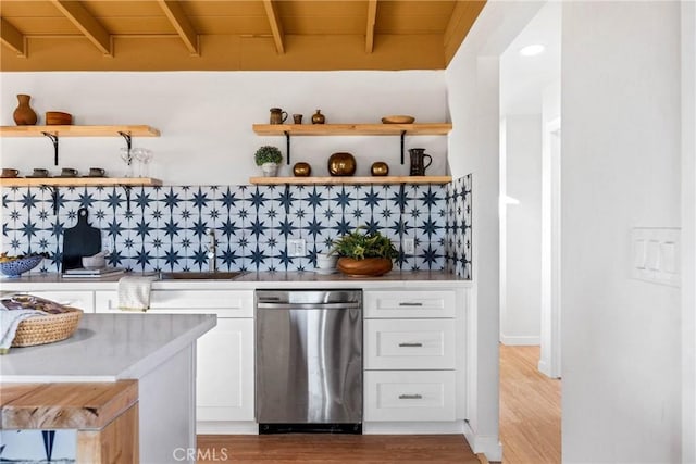 bar featuring stainless steel dishwasher, decorative backsplash, beam ceiling, a sink, and light wood-style flooring