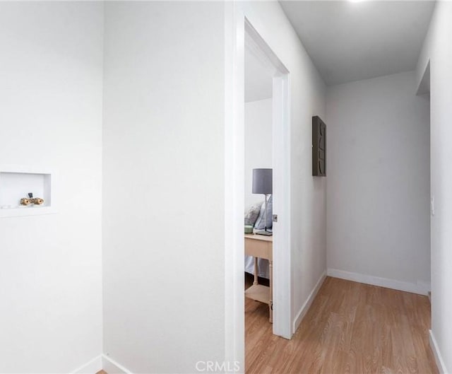 hall with baseboards and wood finished floors