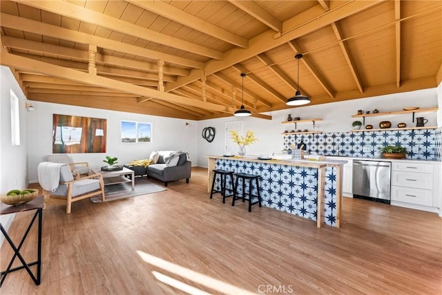 living area with vaulted ceiling with beams, wood finished floors, bar area, and wooden ceiling