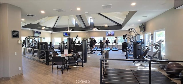 gym with plenty of natural light, ceiling fan, vaulted ceiling, and wood finished floors