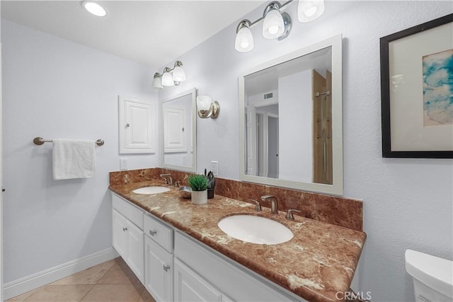 full bath featuring toilet, baseboards, a sink, and tile patterned flooring