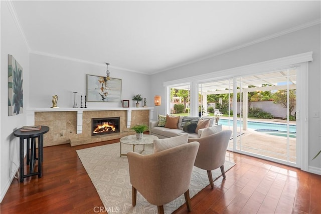 living area with crown molding, wood finished floors, and a premium fireplace