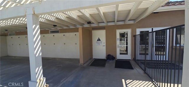property entrance with a carport and stucco siding