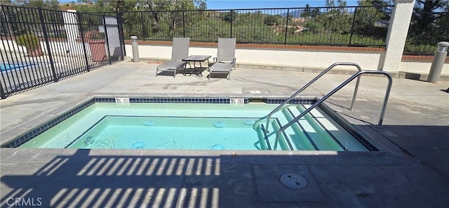 view of swimming pool featuring a patio, fence, and a community hot tub