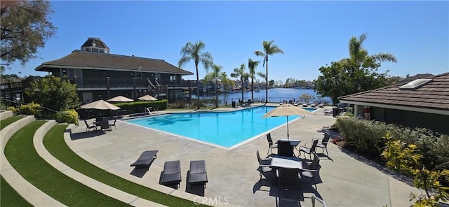 pool with a water view and a patio area