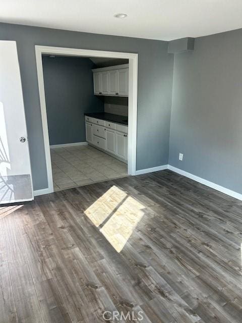 interior space featuring recessed lighting, baseboards, and dark wood-style floors
