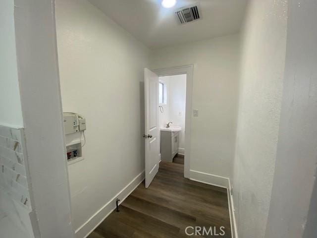 interior space with baseboards, visible vents, and wood finished floors