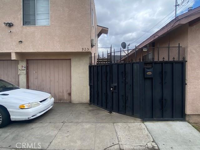view of property exterior featuring fence, a gate, and stucco siding