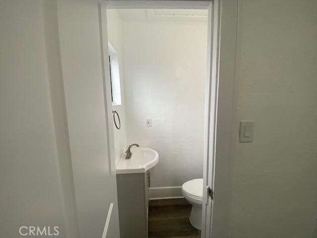 bathroom featuring vanity, baseboards, toilet, and wood finished floors